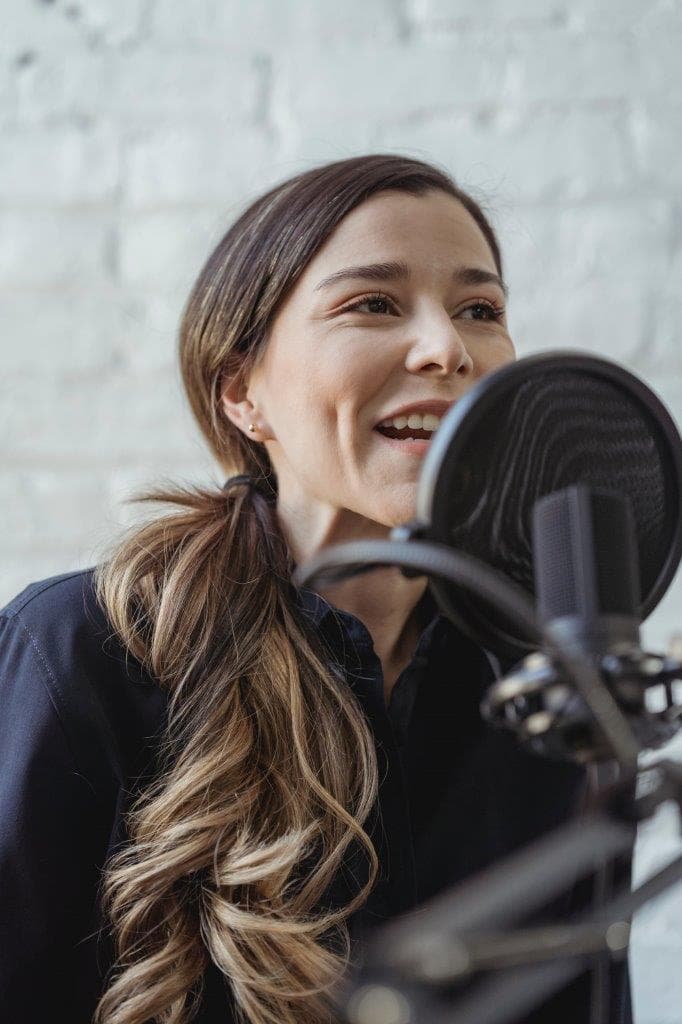 Woman speaking into a podcast microphone